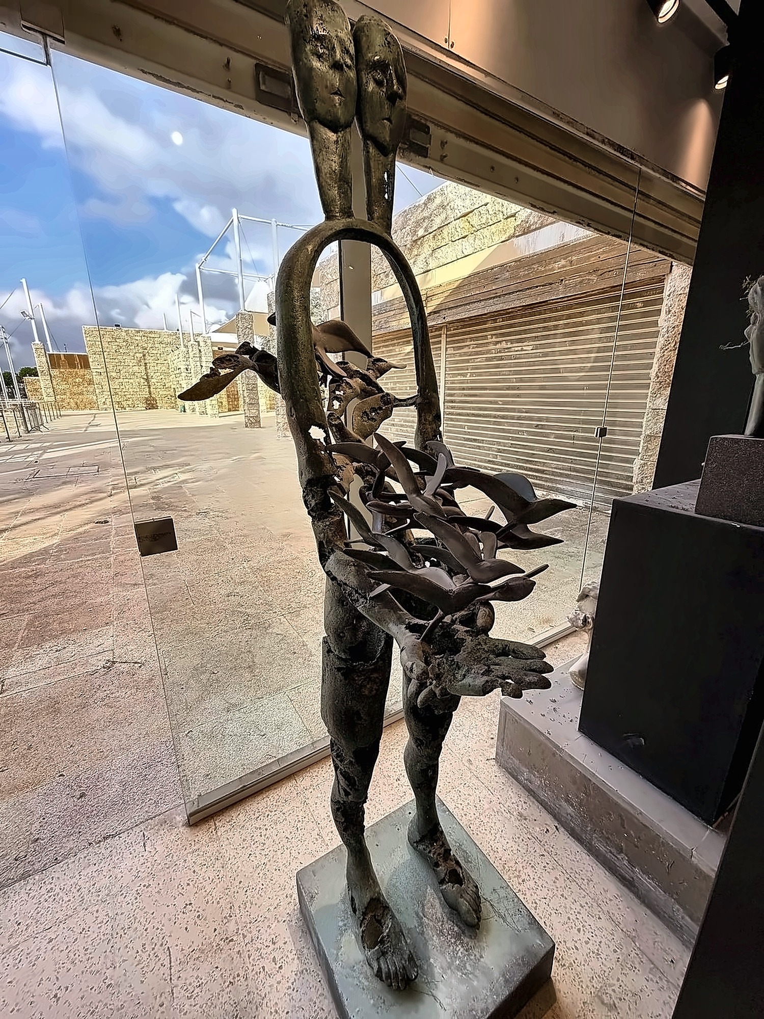 Una figura esculpida que porta un aro y pájaros.
