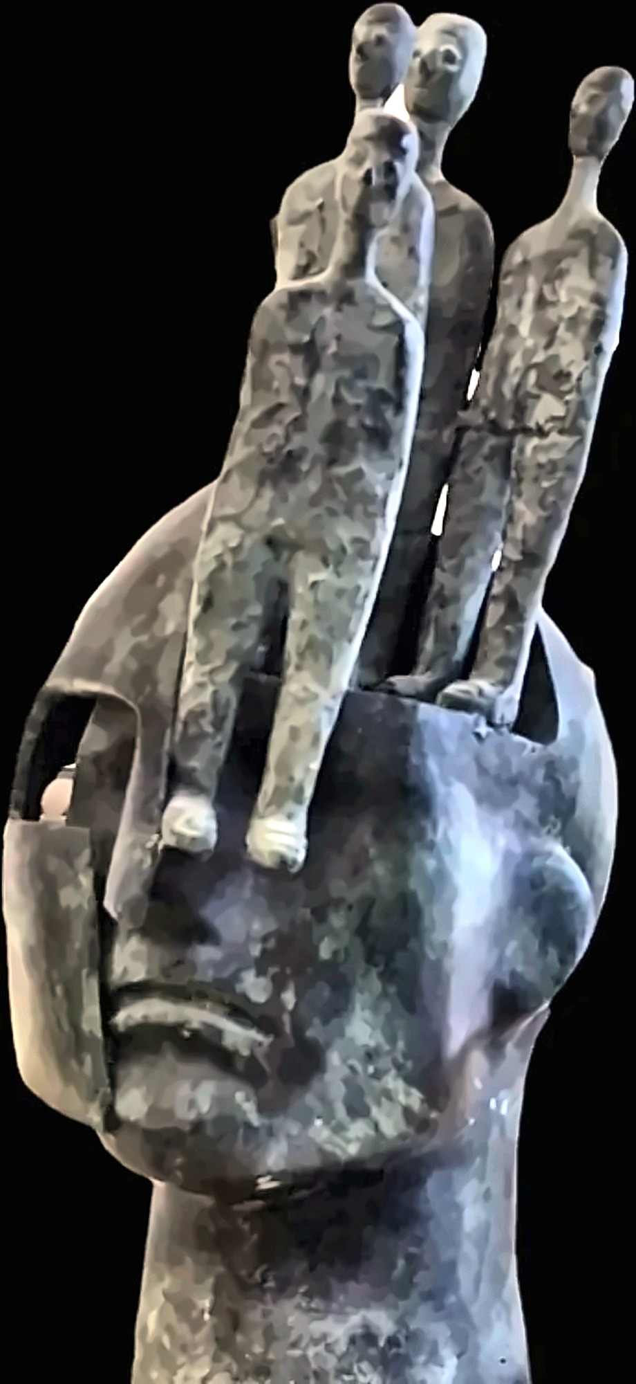 Figuras que emergen de una cabeza esculpida.
