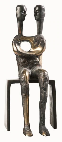 Une figure assise à deux têtes, avec une ouverture circulaire dans le torse.
