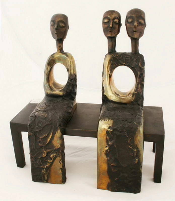 Deux figures assises, trois têtes et deux ouvertures dans les torses.