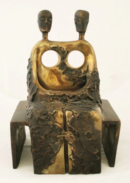 Deux têtes et deux ouvertures circulaires au-dessus d’une forme assise.