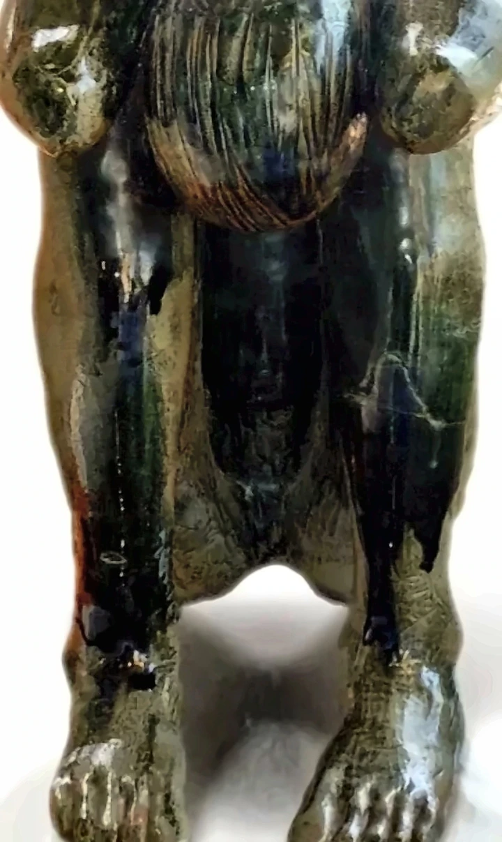 Figura pesada de cerámica con esmalte ocre y verde que corre.