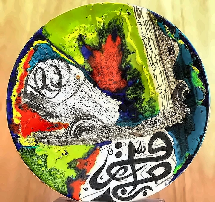 Plato en el que la caligrafía negra se asienta sobre rojo, verde y azul vertidos que se han fundido entre sí.