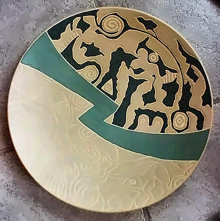 Plato crema cruzado por una banda verde, una mitad incisa con un motivo tenue, la otra llena de figuras negras densas.