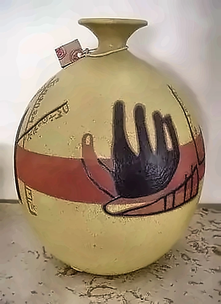 Jarra ocre con una banda roja y una mano negra impresa encima.