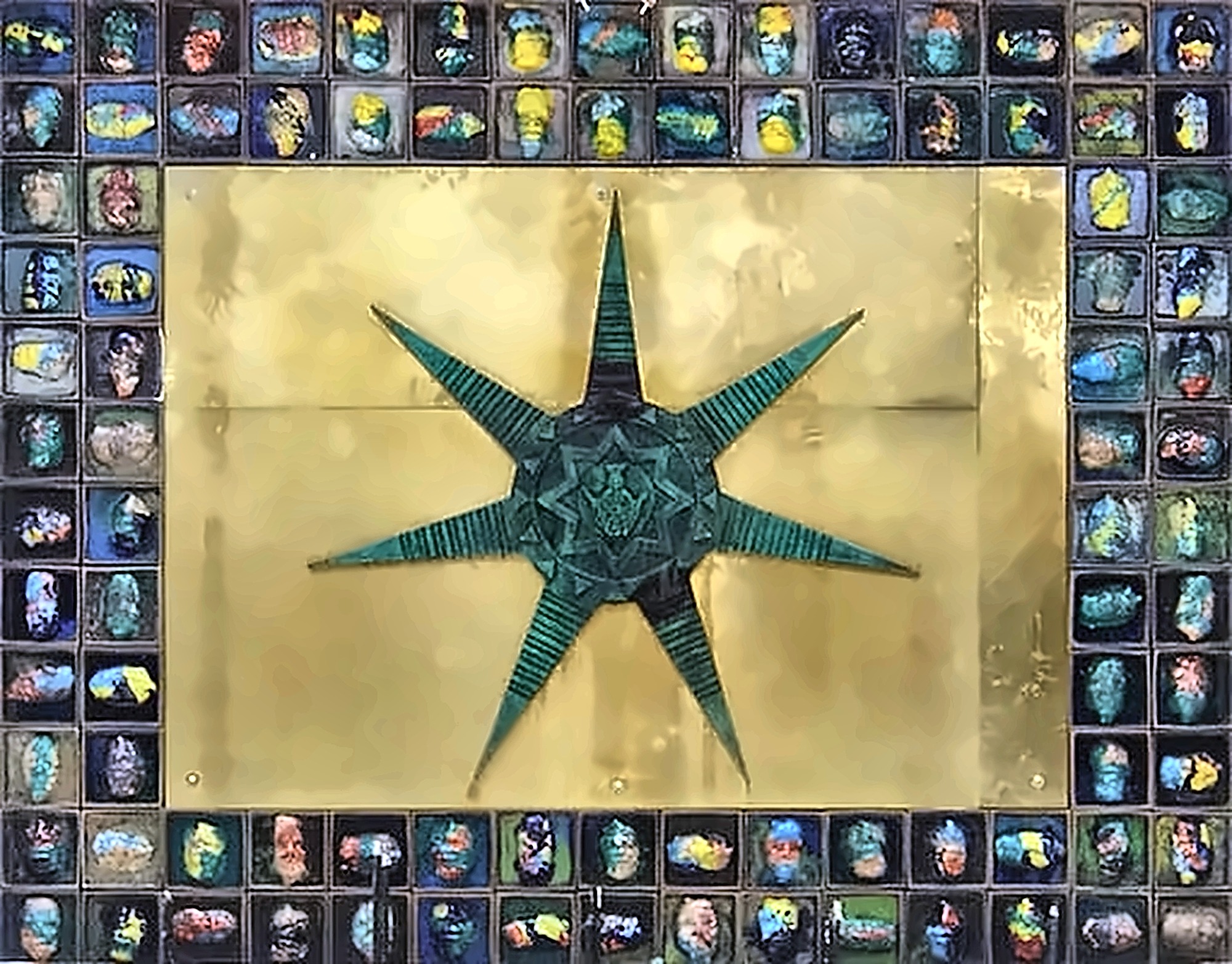 A large panel: a green eight-pointed star on a gold ground, bordered on all four sides by roughly a hundred small tiles, each a painted face in a different colour.