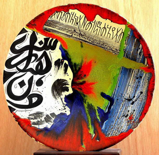 صحن تتوزع عليه كتابة سوداء فوق طلاء زجاجي أحمر وأخضر وأزرق امتزجت ألوانه أثناء الانسياب.